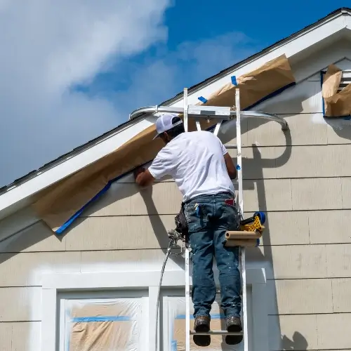 Contractor masking a roof while painting the exterior of a home in Vancouver WA | Clark County Painting